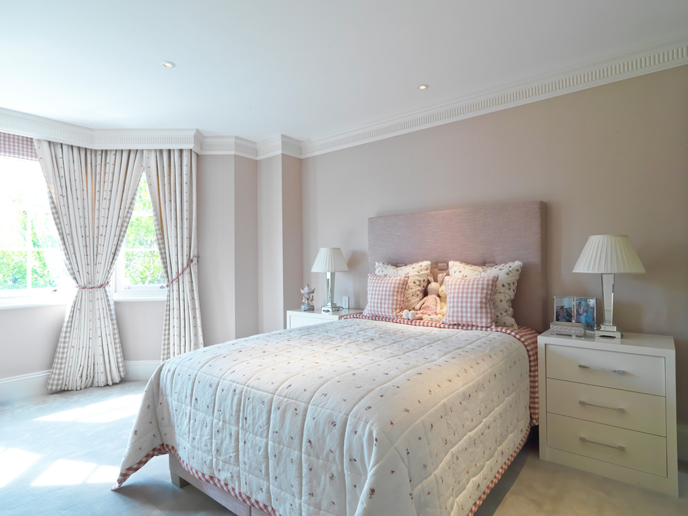 Photo of a mid-sized transitional kids' room for girls in London with beige walls and carpet.