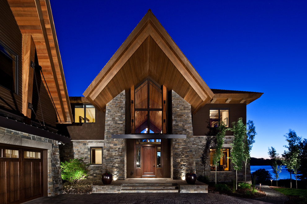Expansive modern three-storey brown exterior in Minneapolis with stone veneer.