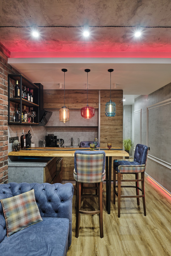 Design ideas for a small industrial u-shaped seated home bar in Moscow with an undermount sink, flat-panel cabinets, medium wood cabinets, wood benchtops, grey splashback, laminate floors, beige floor and turquoise benchtop.