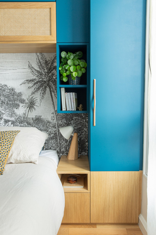 Foto de dormitorio principal tropical pequeño con paredes azules, suelo de madera clara, suelo beige y papel pintado