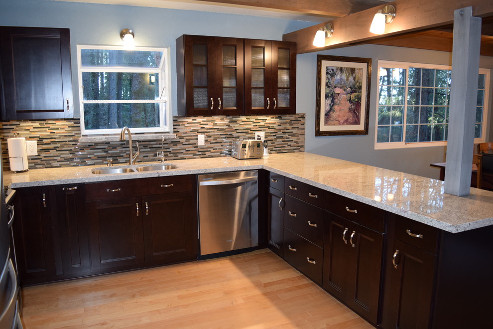 Example of a mid-sized mountain style u-shaped light wood floor eat-in kitchen design with an undermount sink, recessed-panel cabinets, dark wood cabinets, granite countertops, multicolored backsplash, stainless steel appliances and a peninsula