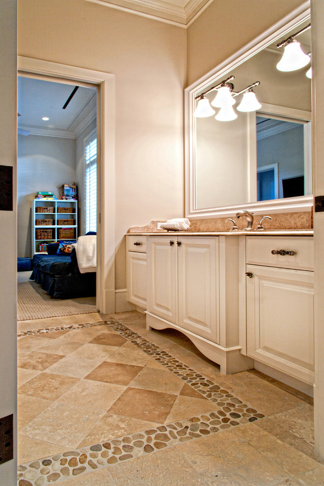 This is an example of a mid-sized traditional bathroom in Miami with raised-panel cabinets, white cabinets, beige walls, travertine floors and an undermount sink.