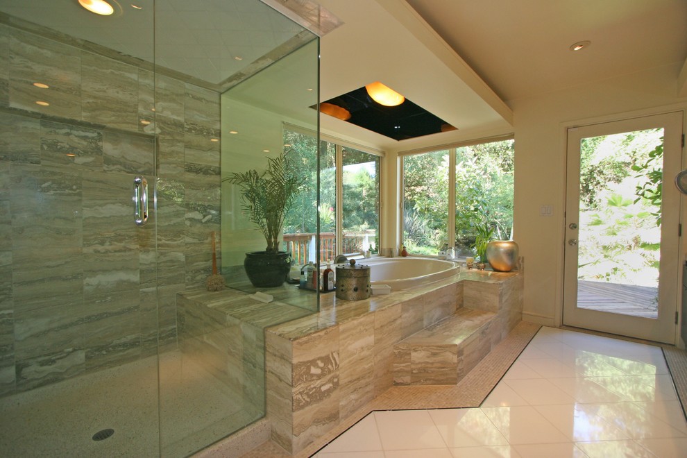 This is an example of a mid-sized contemporary master bathroom in San Francisco with flat-panel cabinets, black cabinets, a drop-in tub, a shower/bathtub combo, multi-coloured tile, marble, marble floors, marble benchtops, multi-coloured floor, a hinged shower door and beige benchtops.