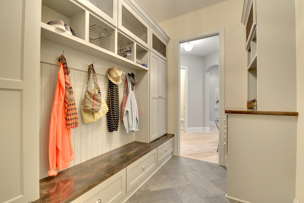 Inspiration for a large transitional mudroom in Minneapolis with beige walls, porcelain floors and a single front door.