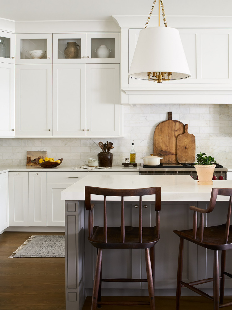 Idéer för ett stort klassiskt vit l-kök, med en rustik diskho, skåp i shakerstil, vita skåp, bänkskiva i kvarts, vitt stänkskydd, stänkskydd i marmor, rostfria vitvaror, ljust trägolv, en köksö och brunt golv