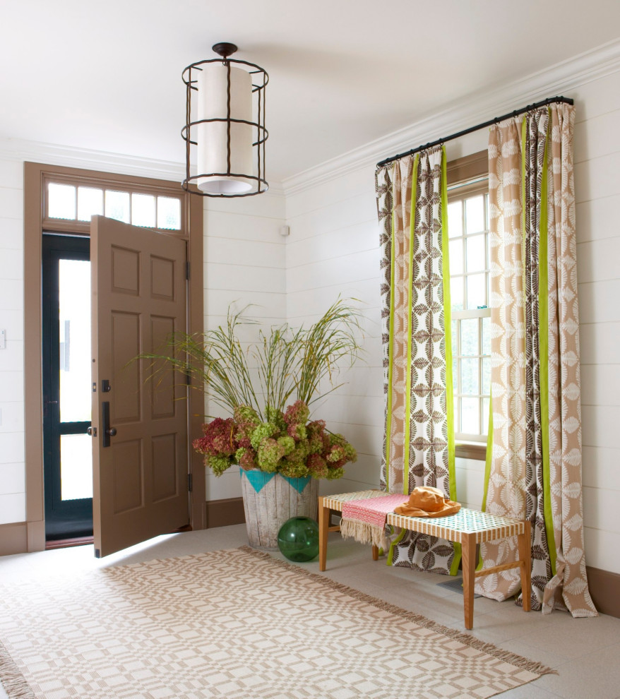 This is an example of a transitional foyer in San Francisco with white walls, a single front door, beige floor and planked wall panelling.