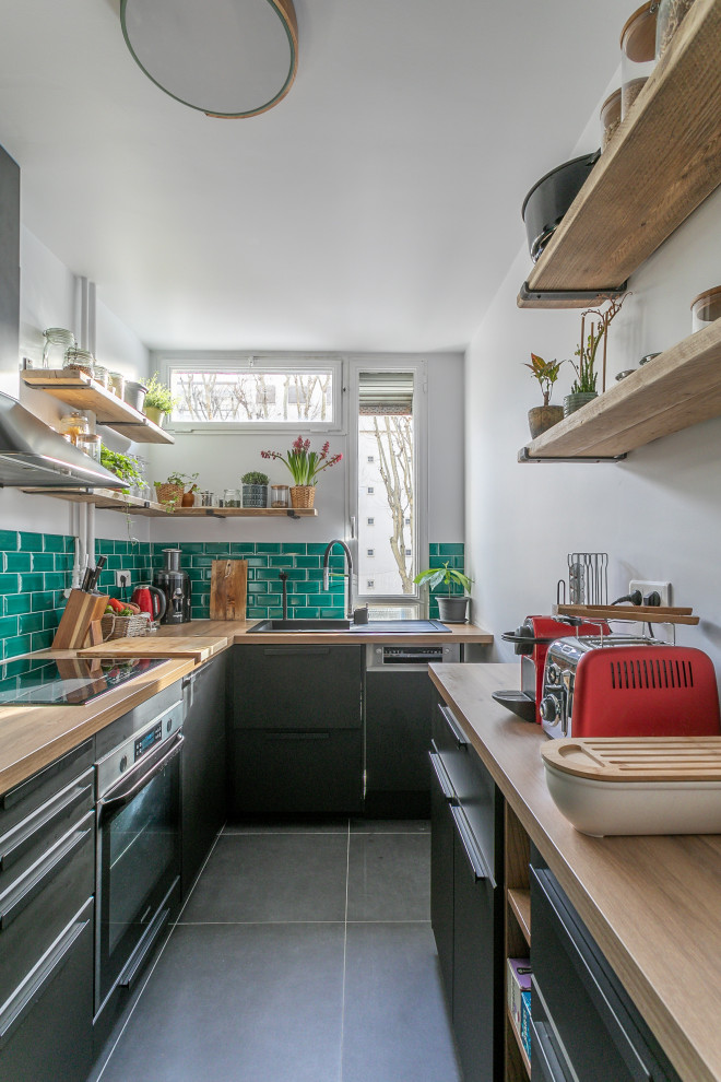 Design ideas for a contemporary u-shaped enclosed kitchen in Paris with a single-bowl sink, beaded cabinets, black cabinets, wood worktops, green splashback, metro tiled splashback, integrated appliances, ceramic flooring, no island, grey floors and brown worktops.