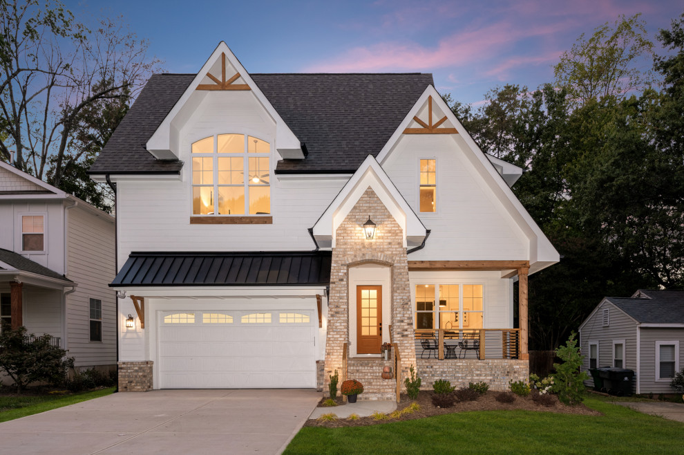 Transitional two-storey brick white house exterior in Charlotte with a black roof.
