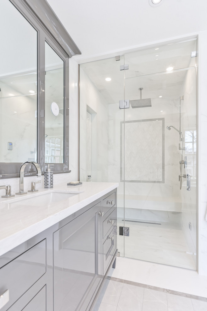 Large transitional master bathroom in Toronto with grey cabinets, a curbless shower, white tile, stone tile, white walls, marble floors, an undermount sink, engineered quartz benchtops, grey floor, a hinged shower door, white benchtops, a shower seat, a single vanity, a freestanding vanity and recessed-panel cabinets.