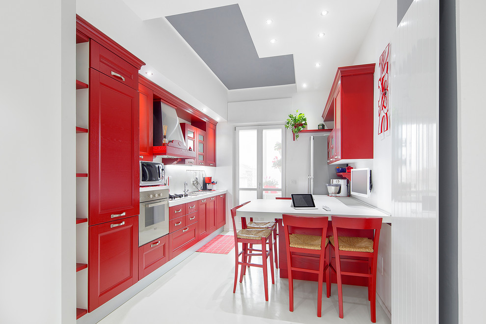 Photo of a mid-sized eclectic single-wall eat-in kitchen in Turin with recessed-panel cabinets, red cabinets, white splashback, stainless steel appliances and porcelain floors.