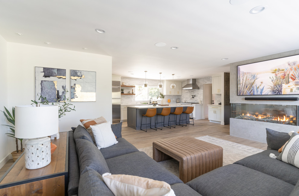 Mid-sized transitional formal open concept living room in Orange County with grey walls, vinyl floors, a corner fireplace, a concrete fireplace surround, brown floor and decorative wall panelling.