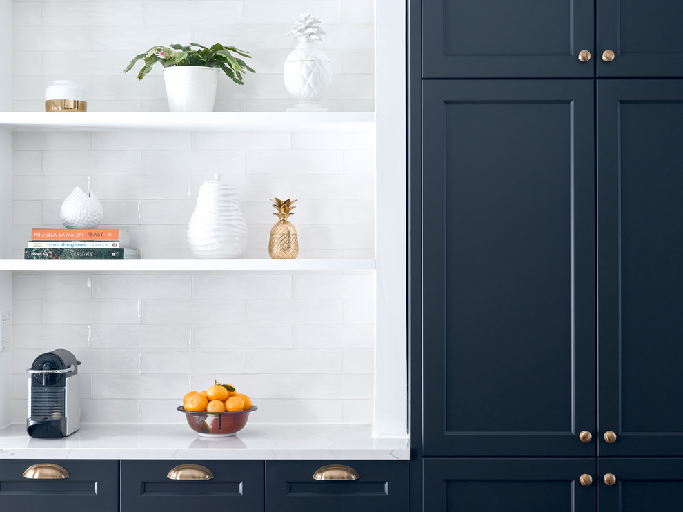 Mid-sized transitional l-shaped medium tone wood floor enclosed kitchen photo in Toronto with an undermount sink, recessed-panel cabinets, blue cabinets, quartz countertops, white backsplash, subway tile backsplash, stainless steel appliances and an island