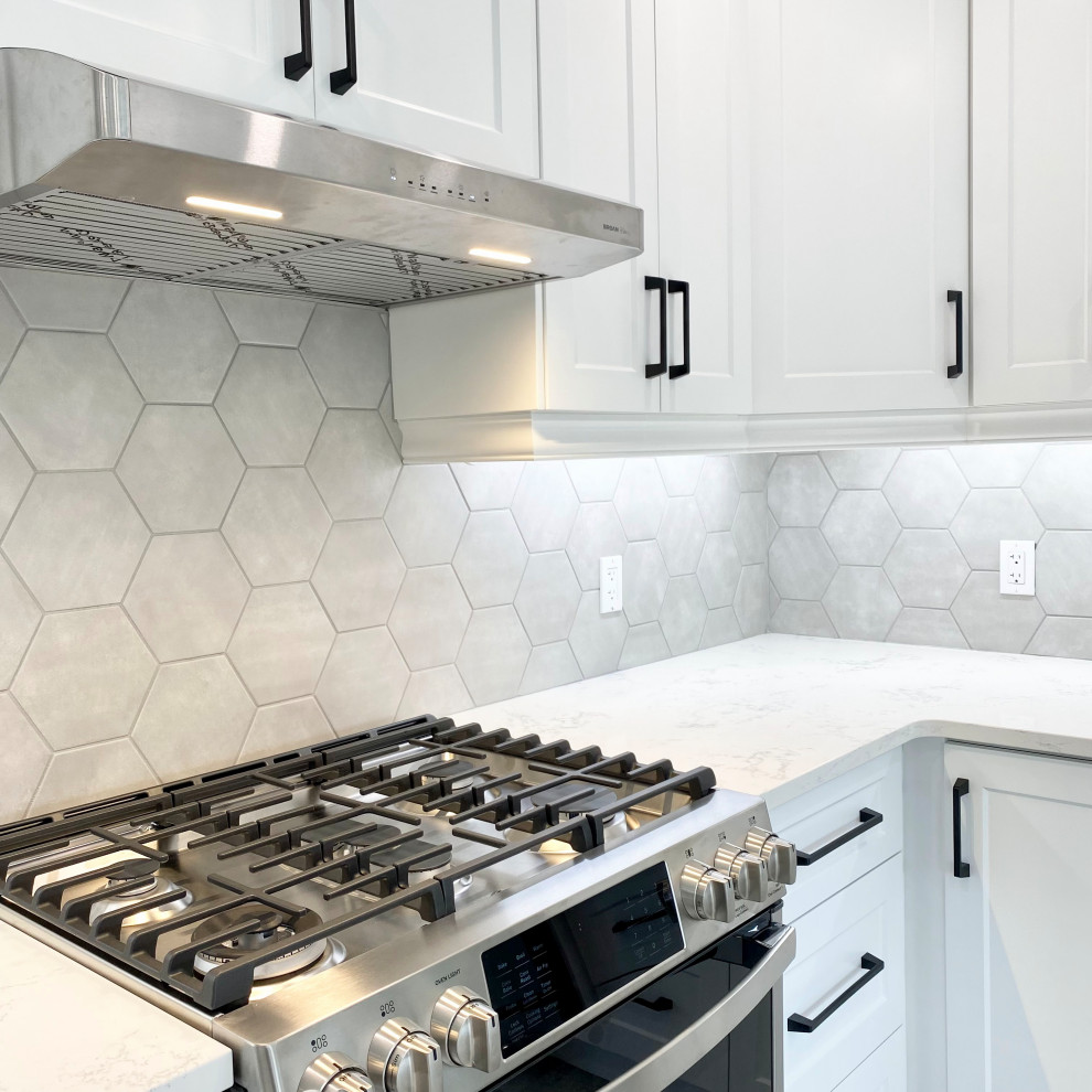 Large transitional u-shaped porcelain tile and gray floor open concept kitchen photo with an undermount sink, recessed-panel cabinets, white cabinets, quartzite countertops, gray backsplash, stainless steel appliances, a peninsula and white countertops