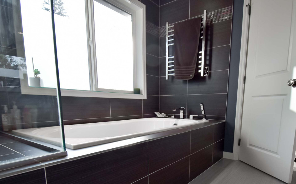 This is an example of a mid-sized modern master bathroom in Portland with a drop-in tub, a corner shower, black tile, ceramic tile, ceramic floors, beige floor and a hinged shower door.