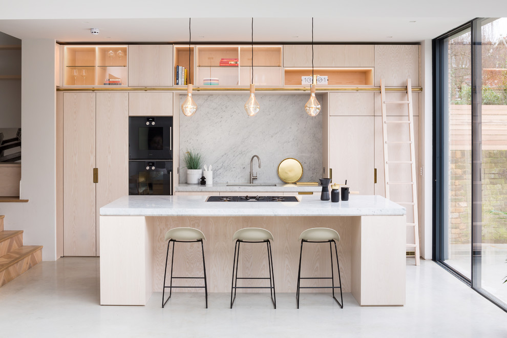 Inspiration for a mid-sized contemporary galley separate kitchen in London with an undermount sink, flat-panel cabinets, light wood cabinets, marble benchtops, grey splashback, marble splashback, black appliances, with island and white floor.