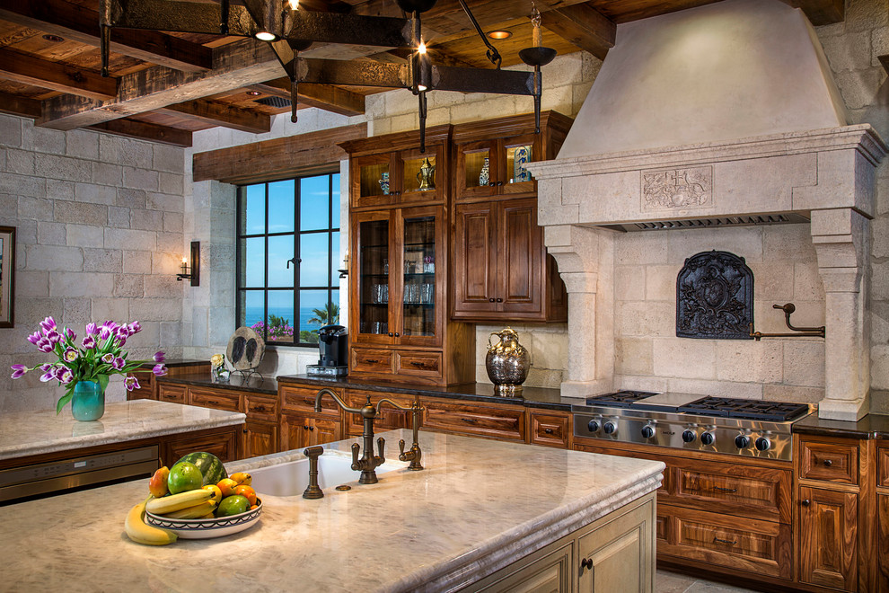 Photo of a mediterranean kitchen in Orange County with an undermount sink, raised-panel cabinets, medium wood cabinets, beige splashback, stainless steel appliances and multiple islands.