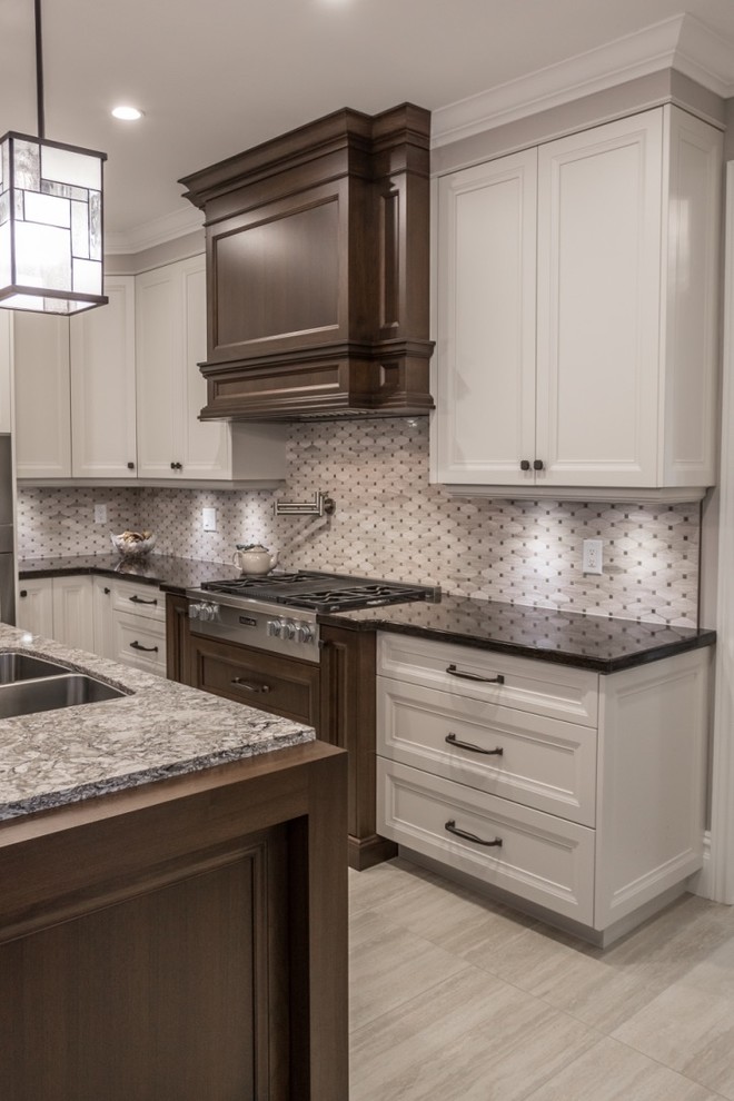 Example of a mid-sized transitional l-shaped ceramic tile eat-in kitchen design in Toronto with an undermount sink, shaker cabinets, granite countertops, mosaic tile backsplash, stainless steel appliances, an island, gray backsplash and white cabinets