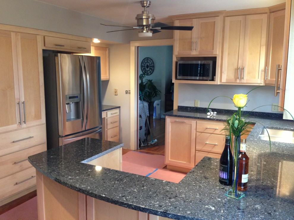 Enclosed kitchen - small transitional u-shaped medium tone wood floor enclosed kitchen idea in Chicago with a double-bowl sink, shaker cabinets, light wood cabinets, quartzite countertops, stainless steel appliances and a peninsula