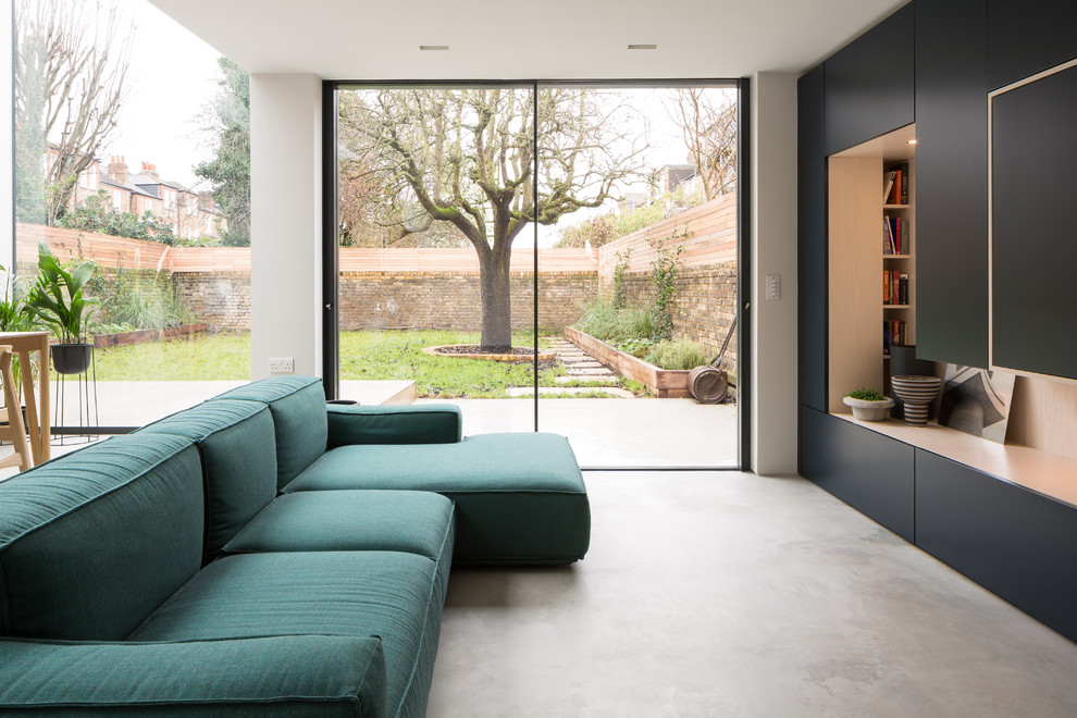 Contemporary formal open concept living room in London with white walls, concrete floors, a built-in media wall and grey floor.