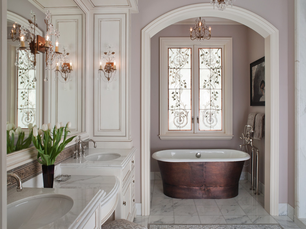 This is an example of a large traditional master bathroom in San Francisco with an undermount sink, recessed-panel cabinets, white cabinets, a freestanding tub, purple walls, marble floors, grey floor and white benchtops.