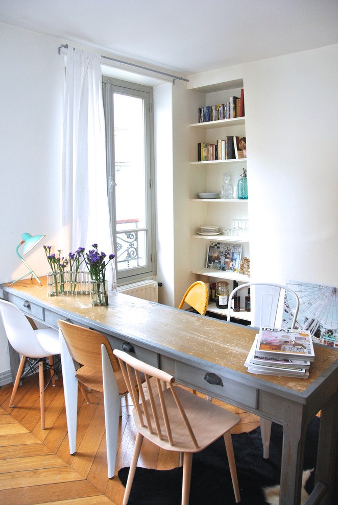 Inspiration for an eclectic dining room in Paris with white walls and medium hardwood floors.