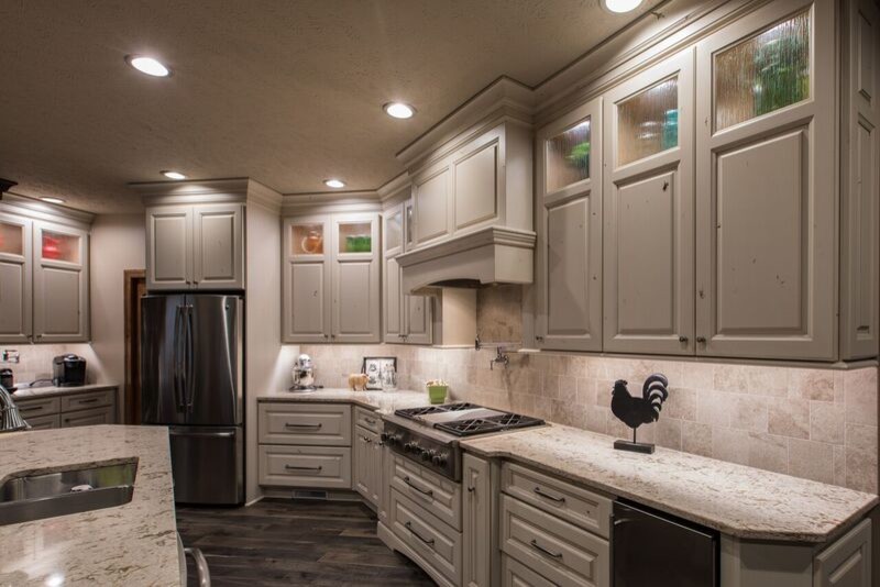 This is an example of a mid-sized transitional open plan kitchen in Other with an undermount sink, raised-panel cabinets, white cabinets, quartz benchtops, stainless steel appliances and with island.