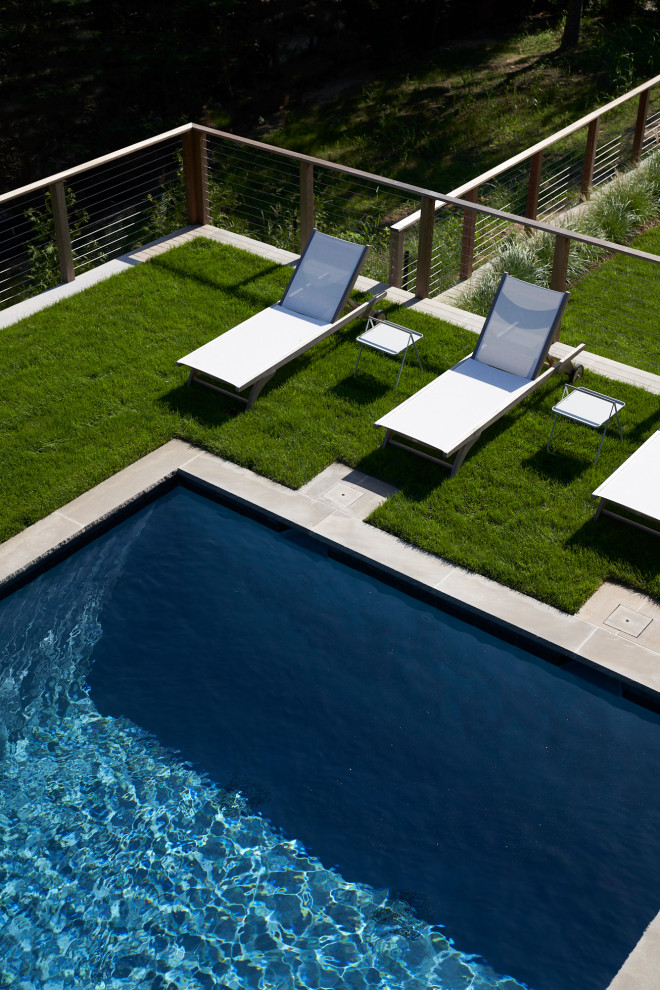 Design ideas for a large contemporary backyard rectangular lap pool in New York with with privacy feature.