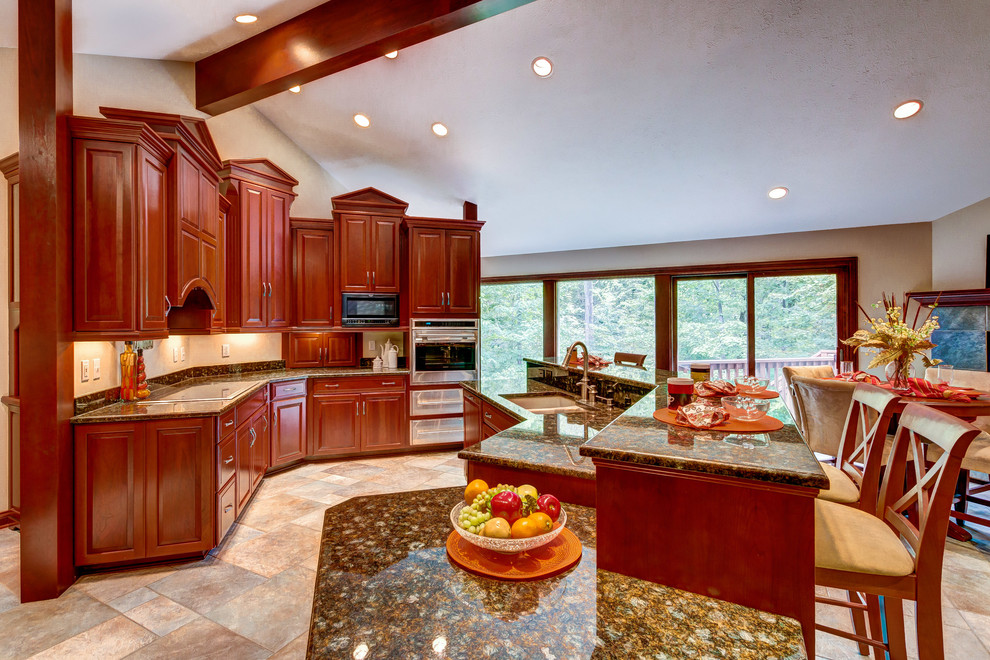 This is an example of an expansive transitional kitchen in Cleveland with an undermount sink, raised-panel cabinets, dark wood cabinets, granite benchtops, panelled appliances, ceramic floors and with island.