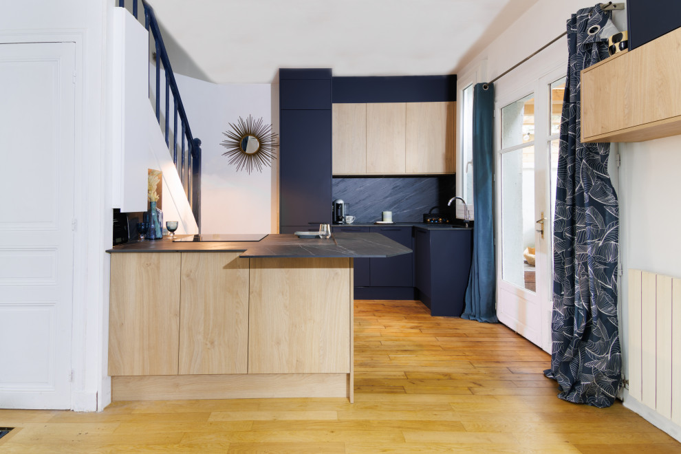 Cette photo montre une cuisine tendance en bois clair avec une crédence grise et un plan de travail gris.