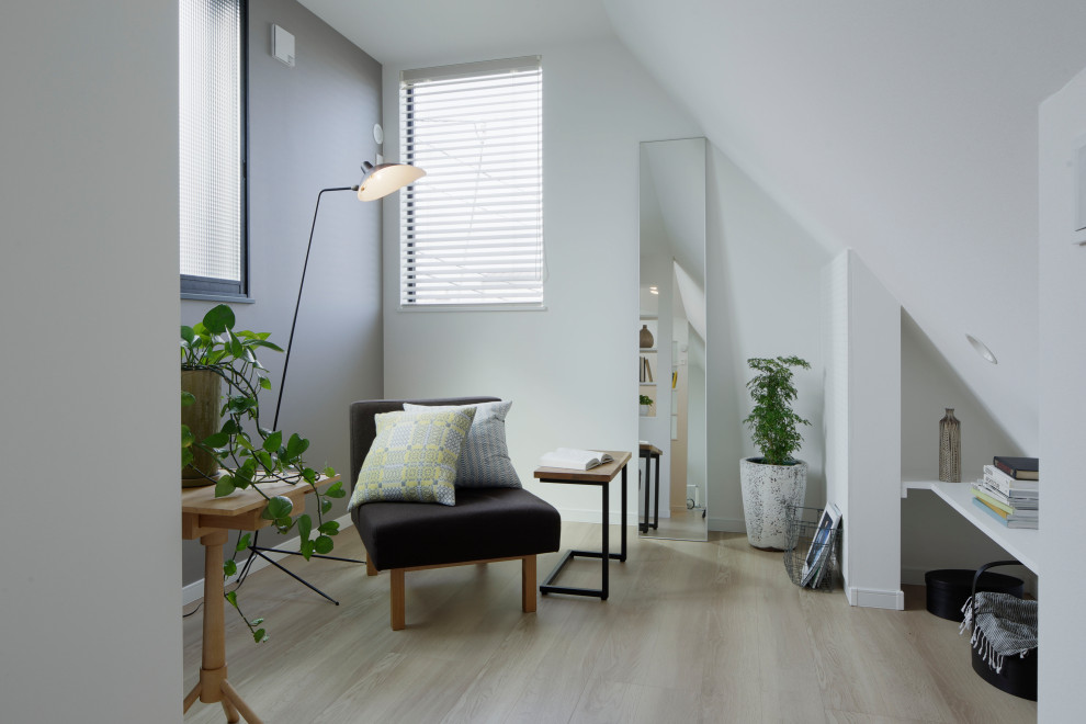 This is an example of a mid-sized scandinavian study room in Tokyo with white walls, light hardwood floors, no fireplace, wallpaper, wallpaper and beige floor.