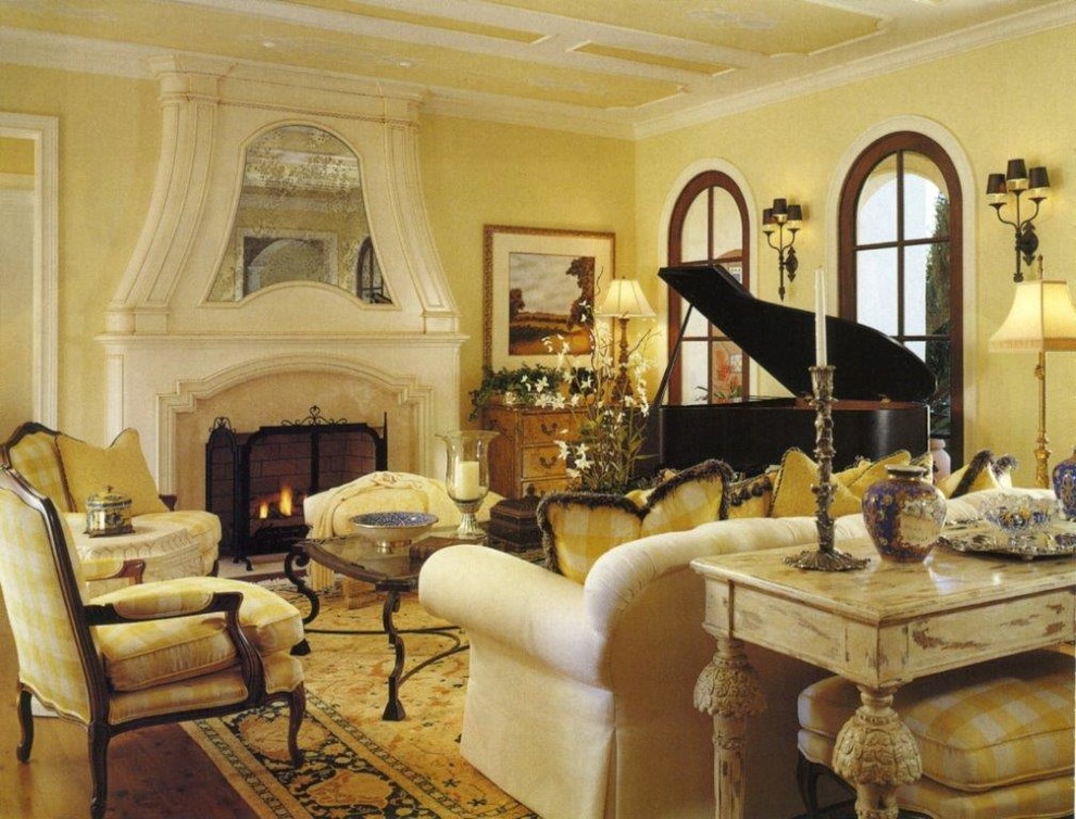This is an example of a mid-sized mediterranean open concept living room in Orlando with a music area, yellow walls, dark hardwood floors, a standard fireplace and a plaster fireplace surround.