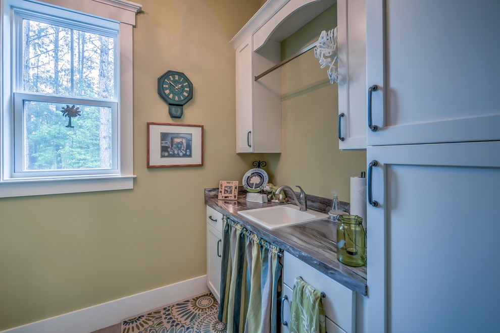 Design ideas for a mid-sized galley dedicated laundry room in Atlanta with a drop-in sink, shaker cabinets, white cabinets, laminate benchtops, beige walls, medium hardwood floors and a side-by-side washer and dryer.