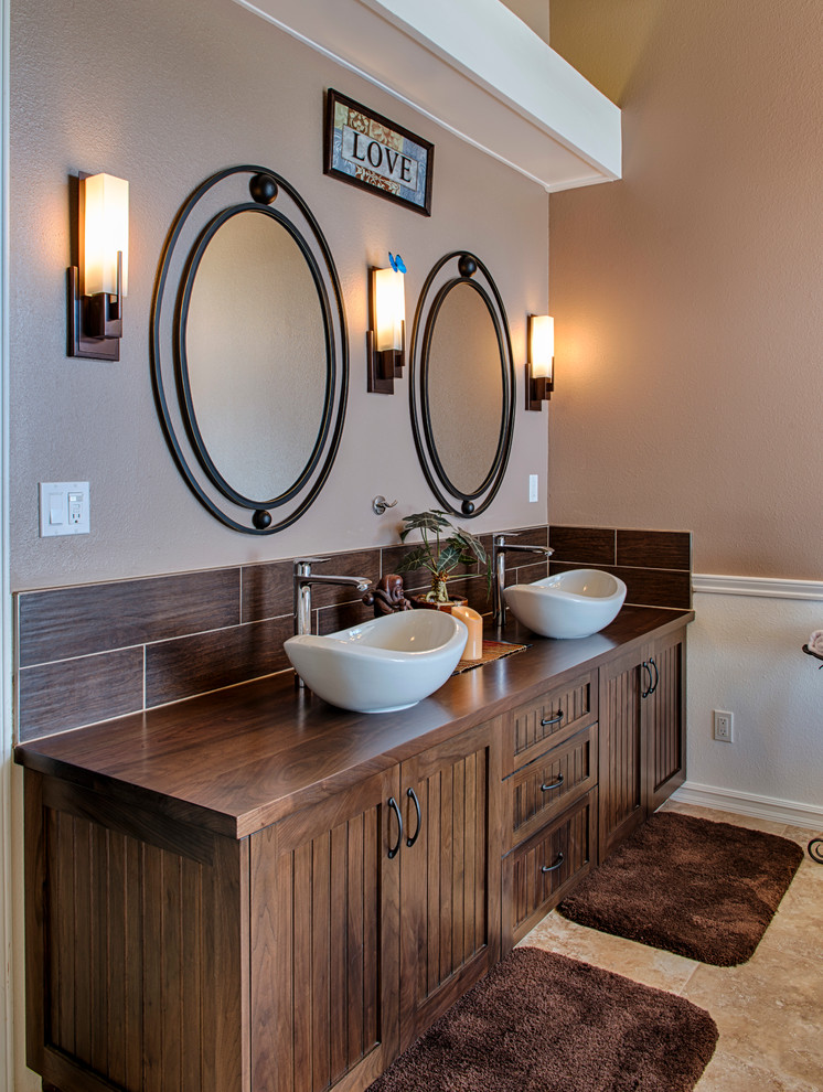 Traditional bathroom in Los Angeles with a vessel sink, dark wood cabinets, wood benchtops, brown tile, brown walls and brown benchtops.