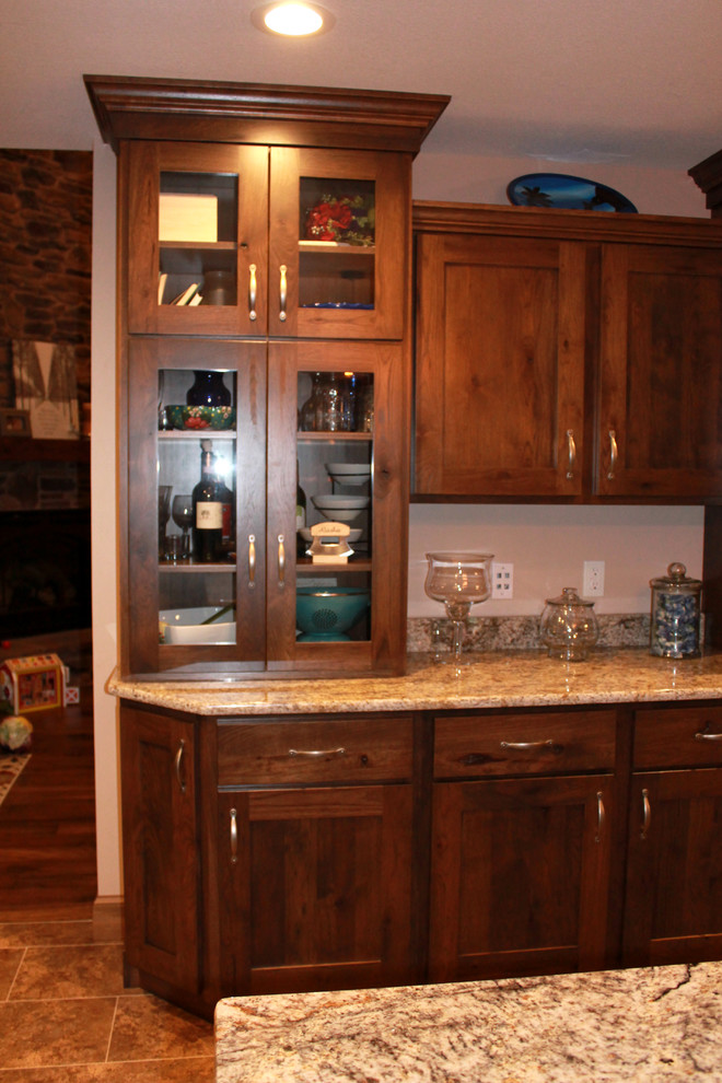 Large mountain style l-shaped eat-in kitchen photo in Chicago with a farmhouse sink, shaker cabinets, dark wood cabinets, granite countertops, stainless steel appliances and an island