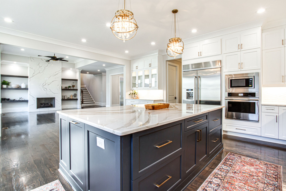 Large transitional u-shaped medium tone wood floor and brown floor open concept kitchen photo in Atlanta with an undermount sink, shaker cabinets, white cabinets, quartz countertops, white backsplash, subway tile backsplash, stainless steel appliances, an island and white countertops