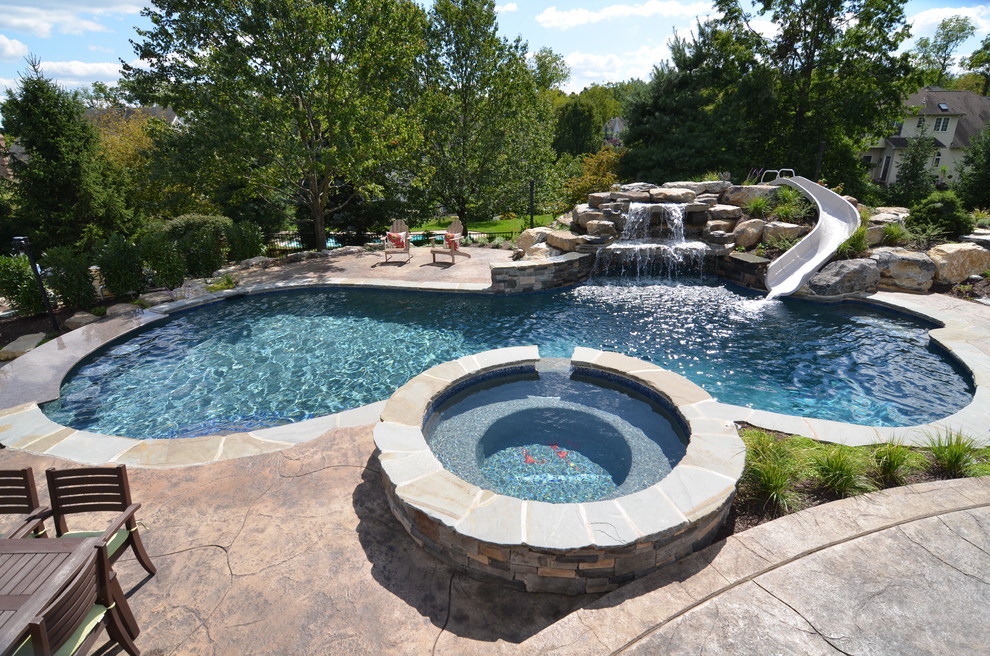Inspiration for a traditional custom-shaped pool in Philadelphia with a water slide.