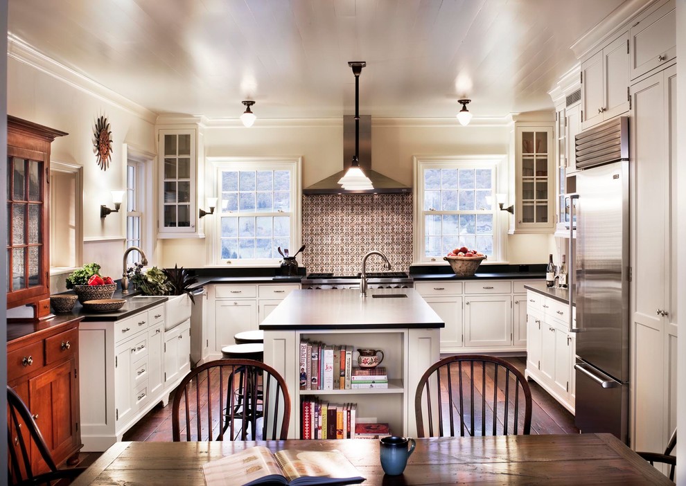 Inspiration for a country u-shaped eat-in kitchen in New York with a farmhouse sink, recessed-panel cabinets, white cabinets, multi-coloured splashback and dark hardwood floors.