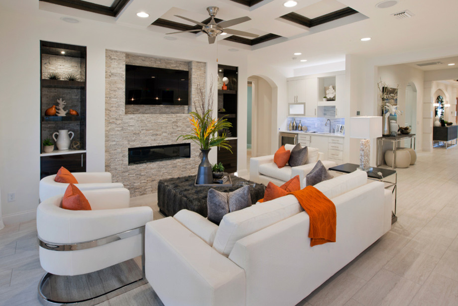 This is an example of a large contemporary open concept living room in Miami with a home bar, white walls, light hardwood floors, a hanging fireplace, a stone fireplace surround and a wall-mounted tv.