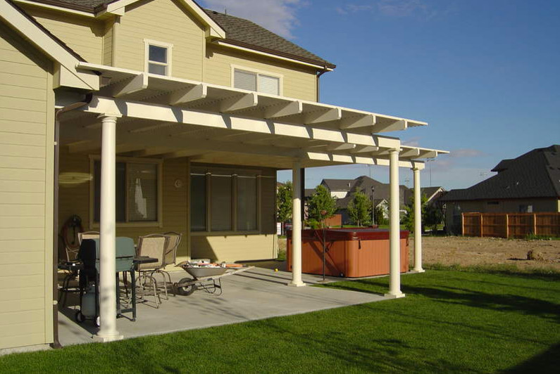 Example of a small transitional side yard deck design in Boise with a roof extension
