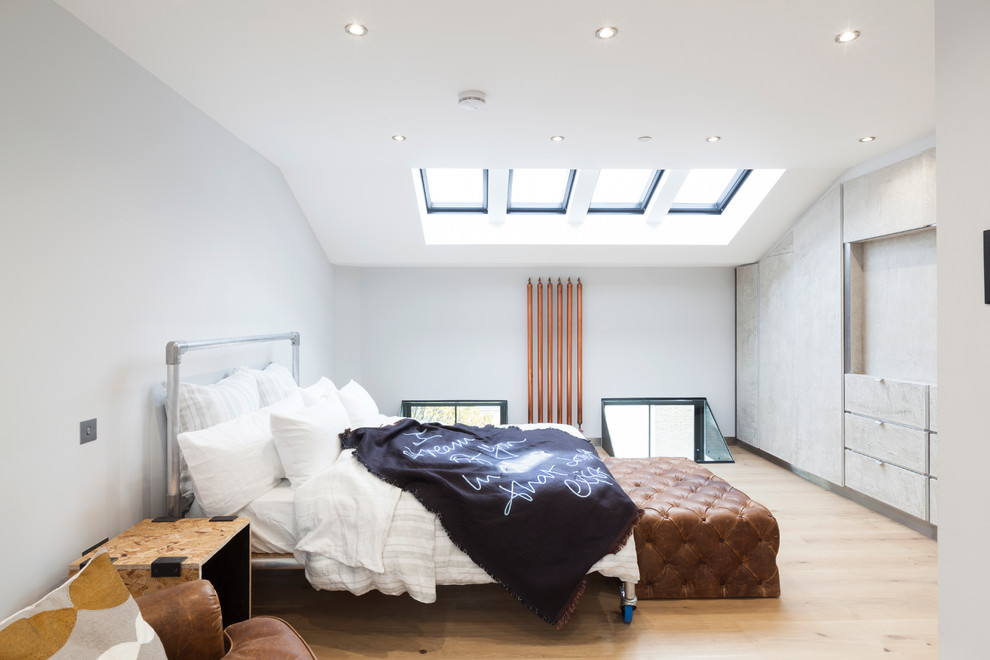 Inspiration for a contemporary bedroom in London with grey walls and light hardwood floors.