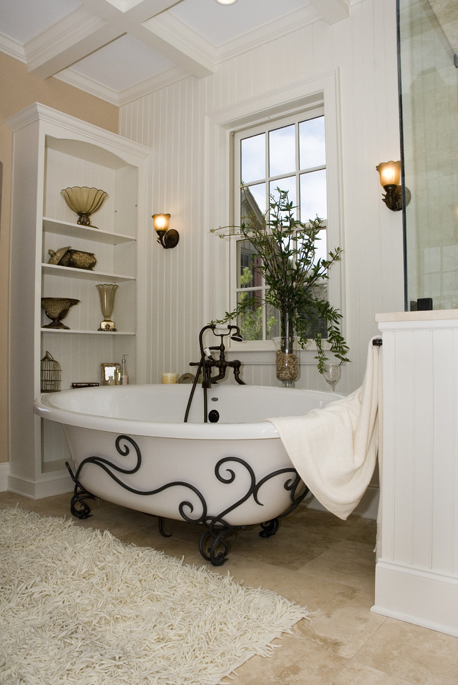 Design ideas for a large mediterranean master bathroom in Huntington with raised-panel cabinets, a claw-foot tub, stone tile, limestone floors, an undermount sink, granite benchtops, beige tile, dark wood cabinets, a corner shower, a two-piece toilet, white walls, beige floor and a hinged shower door.