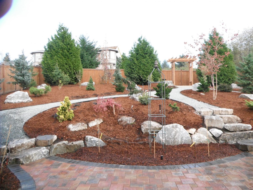 This is an example of a large transitional full sun backyard brick landscaping in Seattle.