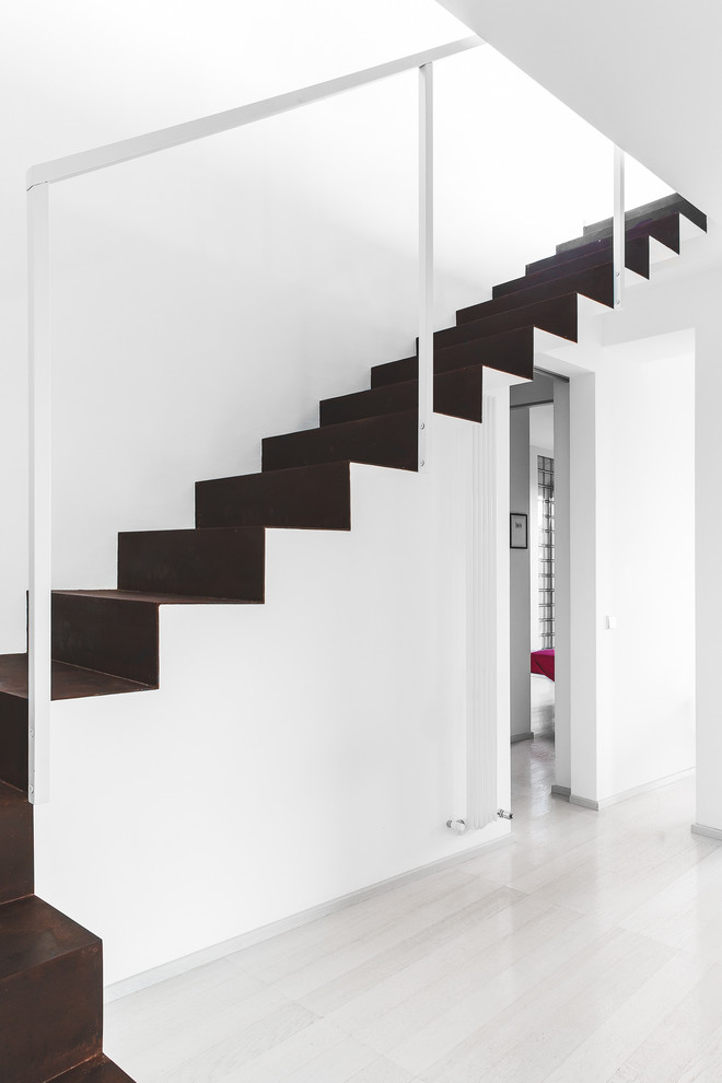 Photo of a small modern metal l-shaped staircase in Bologna with metal risers.