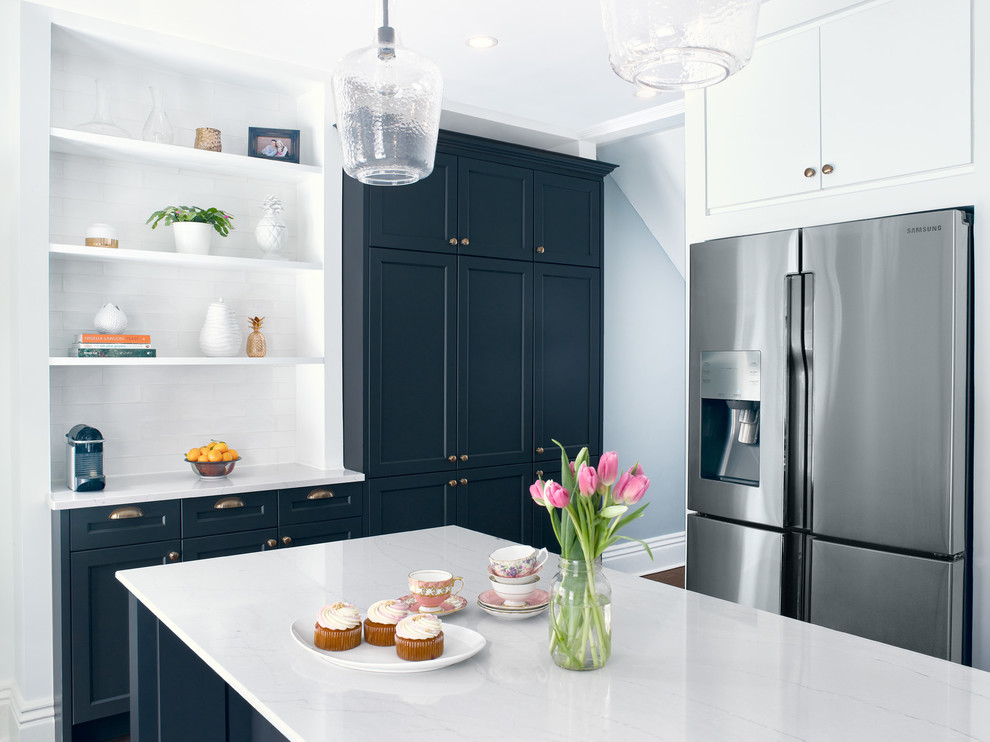 Example of a mid-sized transitional l-shaped medium tone wood floor enclosed kitchen design in Toronto with an undermount sink, recessed-panel cabinets, blue cabinets, quartz countertops, white backsplash, subway tile backsplash, stainless steel appliances and an island