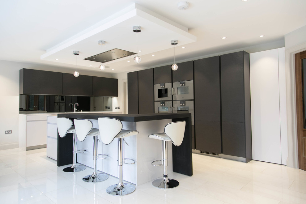Inspiration for a contemporary l-shaped kitchen in London with flat-panel cabinets, dark wood cabinets, stainless steel appliances and with island.