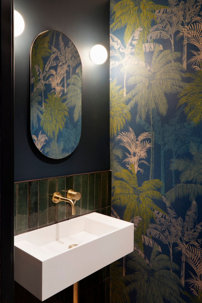 Kleine Moderne Gästetoilette mit Wandtoilette, grünen Fliesen, Porzellanfliesen, bunten Wänden, braunem Holzboden, Wandwaschbecken und Tapetenwänden in London