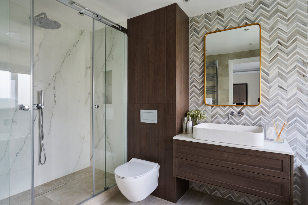 Medium sized modern ensuite bathroom in London with shaker cabinets, brown cabinets, a walk-in shower, a wall mounted toilet, brown tiles, porcelain tiles, brown walls, porcelain flooring, a vessel sink, marble worktops, brown floors, a hinged door, grey worktops, a single sink and a floating vanity unit.