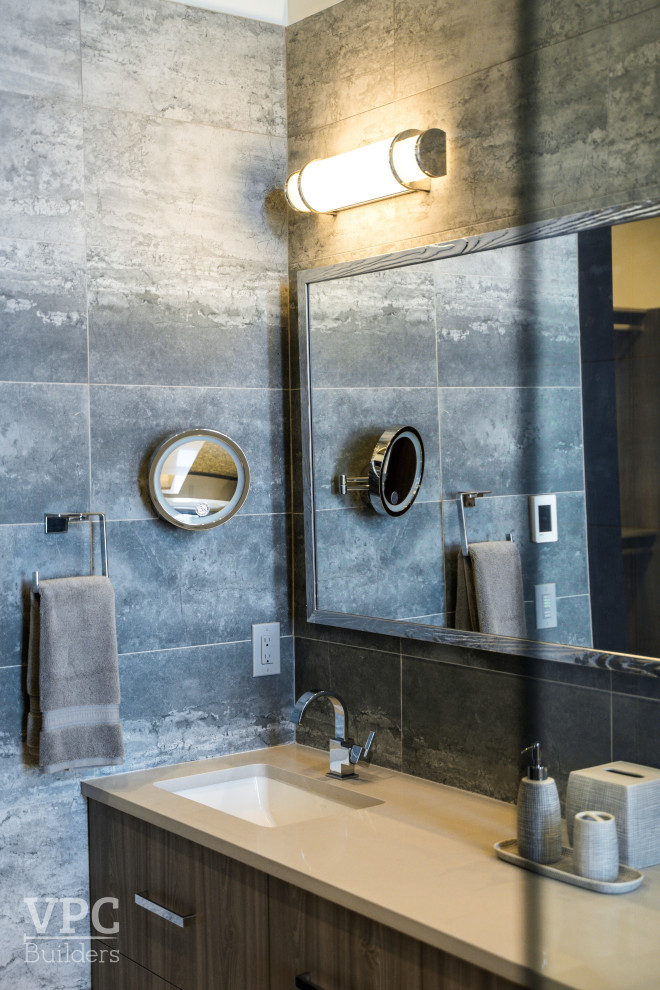 Modern inredning av ett mellanstort beige beige badrum med dusch, med skåp i mellenmörkt trä, ett fristående badkar, en hörndusch, grå kakel, grå väggar, ett fristående handfat och med dusch som är öppen