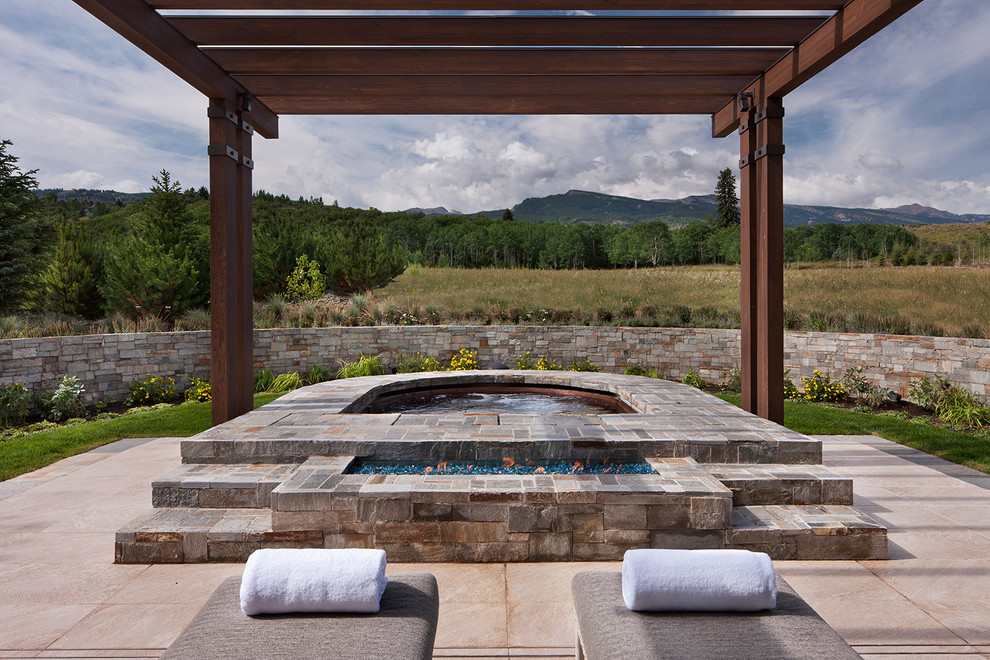 Inspiration for a country backyard pool in Denver with a hot tub.
