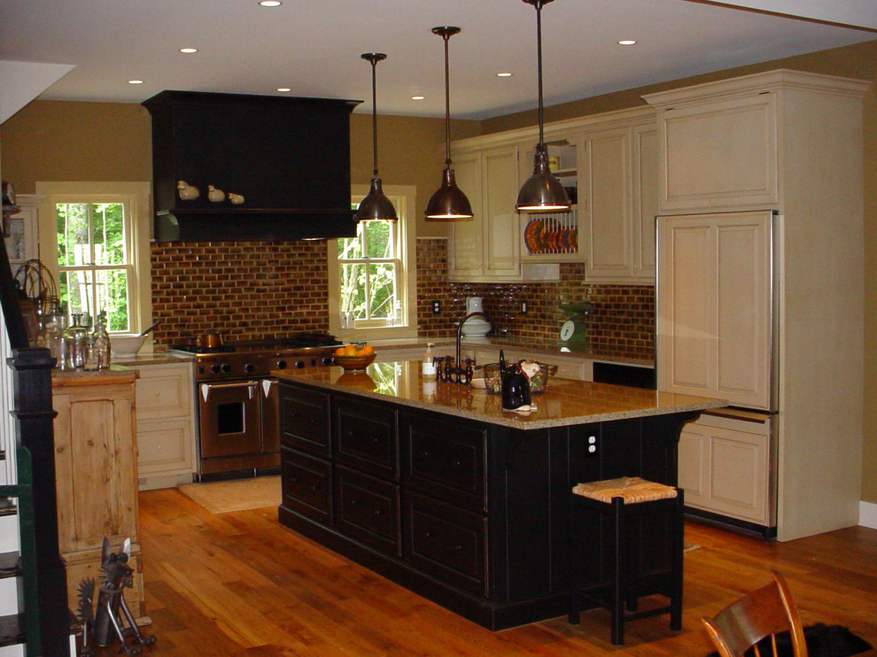 Design ideas for a traditional l-shaped eat-in kitchen in DC Metro with an undermount sink, raised-panel cabinets, distressed cabinets, granite benchtops, brown splashback, subway tile splashback and panelled appliances.